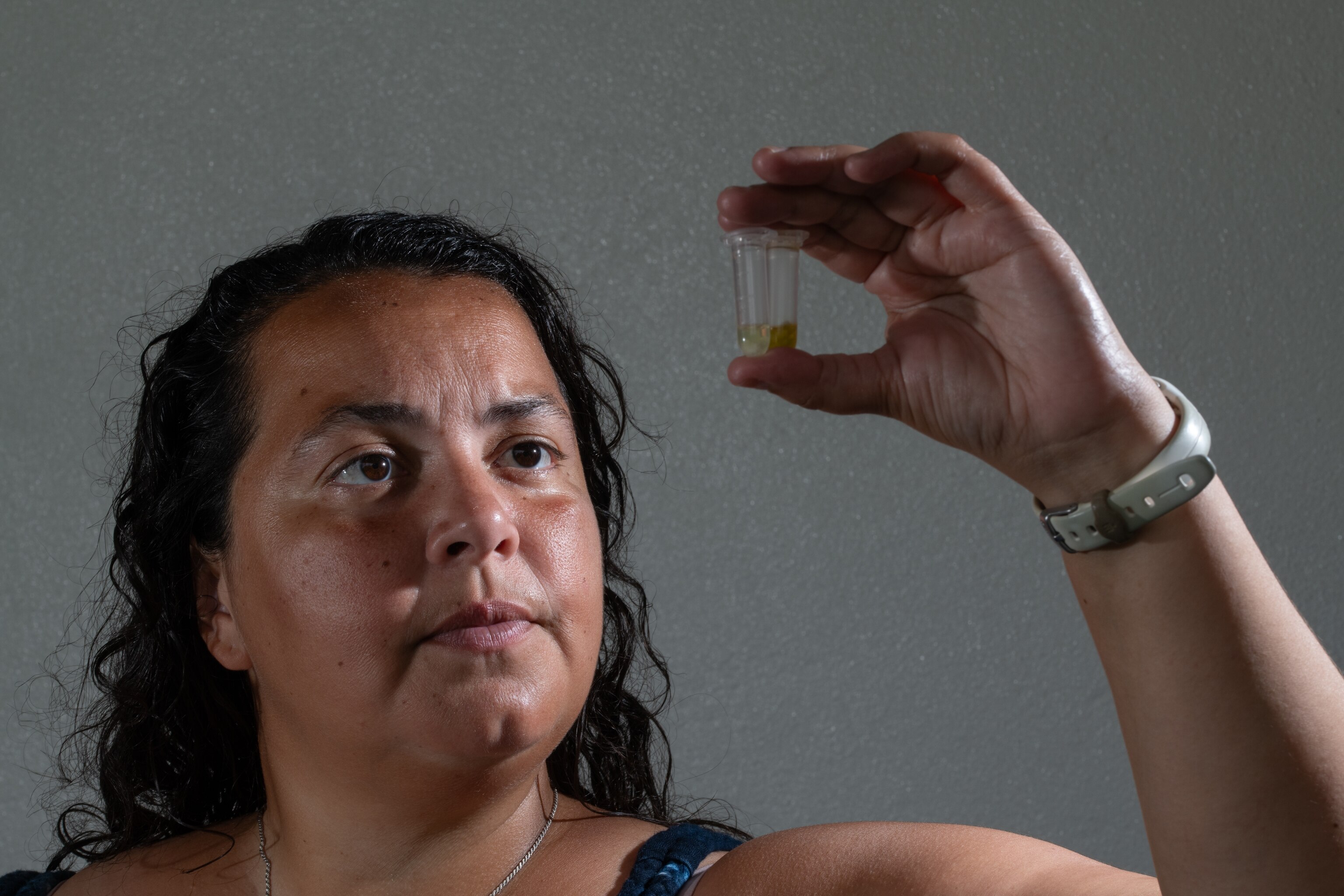 National Geographic Explorer Anya Brown holds two samples of the same coral tested for chlorophyll extractions.